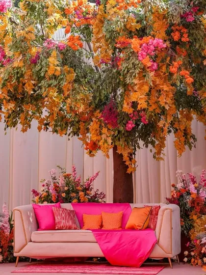 A full view of the magnificent floral tree stage, with the couple's sofa nestled amongst a garden of colorful flowers.