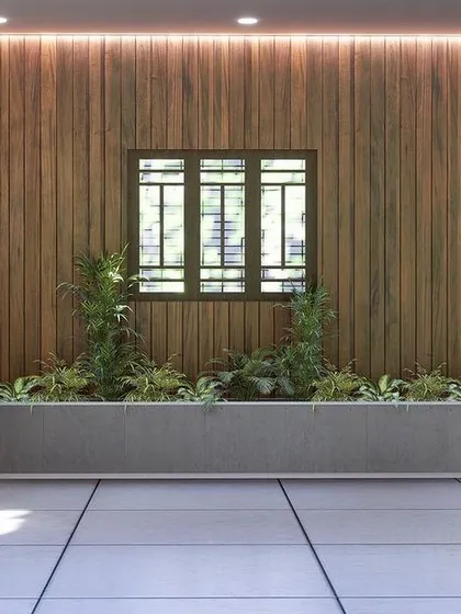 Even a parking area can be beautiful. This design incorporates a wooden accent wall and a built-in planter bed to add greenery and style to a functional space.