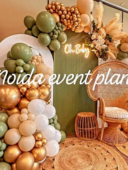 We love creating boho-themed baby showers using natural textures like this wicker peacock chair, jute rugs, and pampas grass, paired with olive green and gold balloons.