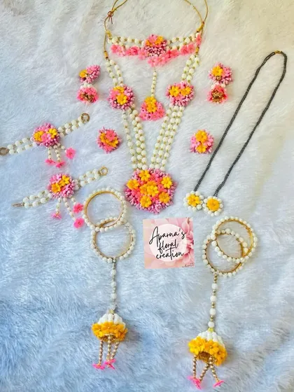 A very colorful halwa jewellery set, perfect for a vibrant Sankranti celebration. This set uses pink, yellow, and orange floral accents.