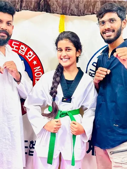 A student smiles after receiving her green belt.