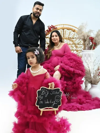 A heartwarming family maternity photo celebrating the arrival of a new member. The older daughter holds a "Big Sister in Waiting" sign, showing how I love to include the entire family in these precious moments.