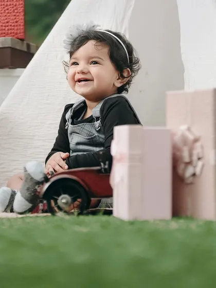 A close-up of a happy little girl enjoying her birthday shoot. Her bright smile and the soft background create a beautiful, heartwarming portrait.
