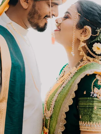 An artistic close-up that beautifully frames the bride's profile and traditional jewelry. The bright, clean background puts all the focus on her and the groom's adoring gaze.