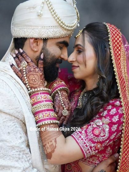 An intimate and romantic pose. The bride's mehendi-adorned hands frame the groom's face, a beautiful gesture of love and affection on their wedding day.