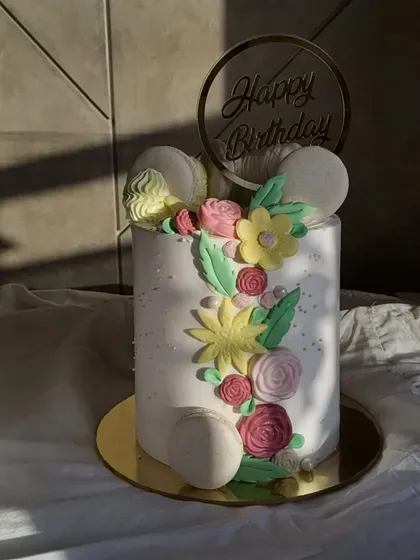 Simply gorgeous, isn't it? This tall birthday cake features a cascade of hand-molded fondant flowers and macarons in soft pastel colours.