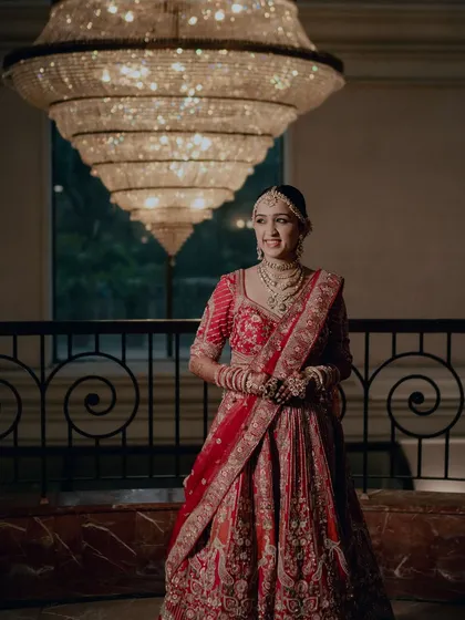 Posing under a grand chandelier, Twinkle looks every bit the royal bride. Her makeup is luminous and her smile is radiant.
