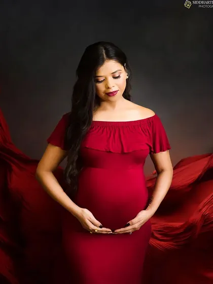 The beauty of a mother-to-be is timeless. In this classic maternity portrait, I use flowing red fabric against a dark, moody background to create a sense of drama and elegance, drawing all the attention to you and your bump.