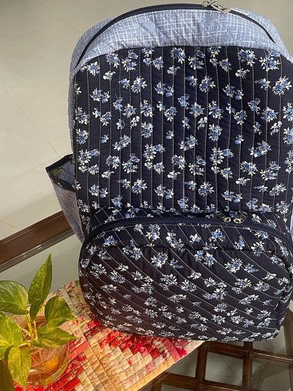 The front of the organizer backpack, showing the zippered front pocket and the combination of two coordinating fabrics.