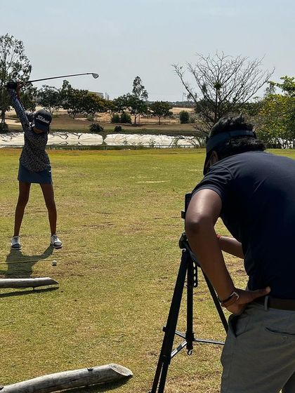 We are invested in the success of all our athletes. Here, a coach uses a camera to record a player's swing for detailed analysis.