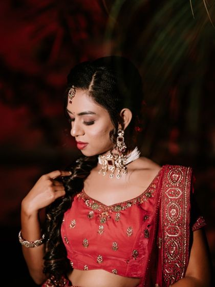 A beautiful portrait of the bride during her Mehendi ceremony. The warm, red lighting enhances the richness of her attire and the festive mood.