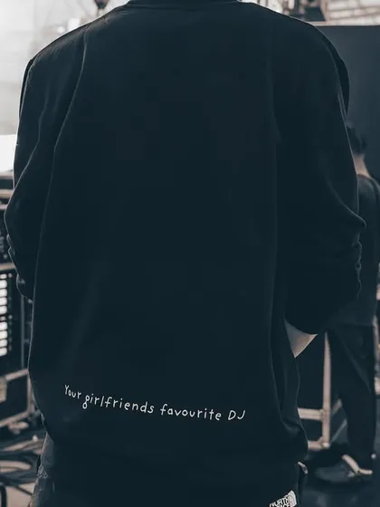 A shot of the back of my custom sweatshirt, reading "your girlfriends favourite DJ". It's a glimpse into my cheeky and confident brand persona.