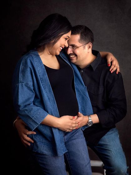 The laughter and love between these two is everything! This candid shot was taken during their denim-themed studio session against a classic dark backdrop.