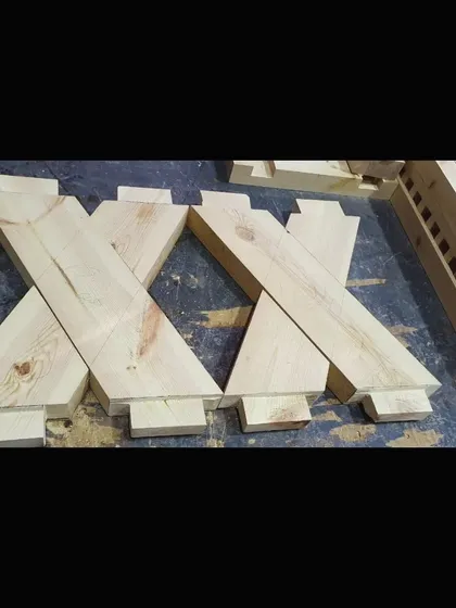 Here, the complex cross-lap joints for the bench legs are cut and ready. This type of joinery requires careful measurement and precise cutting to ensure a strong and stable base.