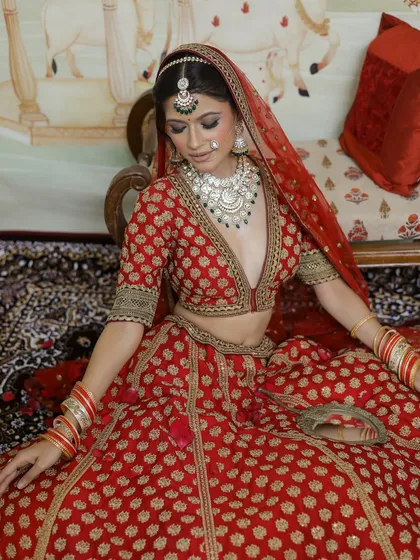 A beautiful seated portrait that captures the richness of the bridal attire and the elegance of the makeup. The focus is on creating a look that is both traditional and comfortable.