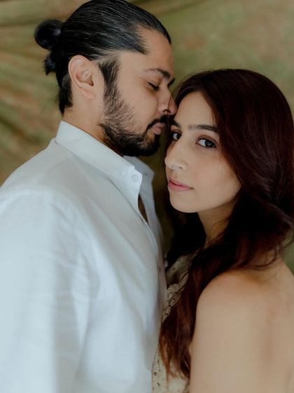 An intimate portrait with a soft, romantic feel. The groom's gentle kiss on her forehead and her serene expression make this a beautifully tender moment.