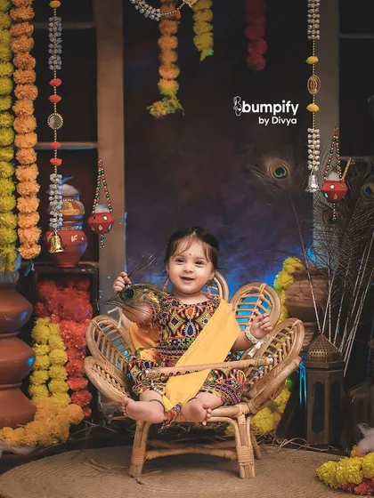 This little Radha is full of joy in our colorful and rustic Janmashtami studio. The details, from the hanging bells to the marigolds, complete the scene.