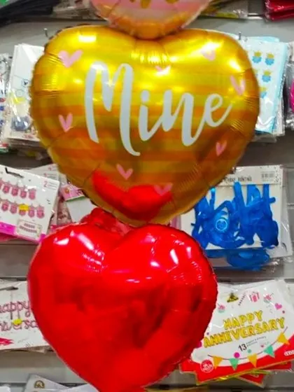A simple and sweet gesture for your special someone. This image showcases our heart-shaped foil balloons, including a golden one with the word 'Mine' and a classic red heart, perfect for any romantic occasion.