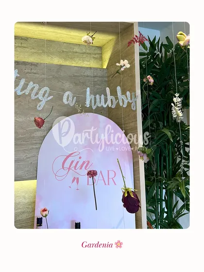 Gardenia. For the bride who loves a calm, serene vibe, this 'Getting a Hubby' Gin Bar setup with hanging florals is a perfect choice for a bridal shower.