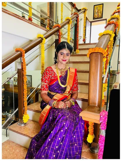 This pose captures the elegance of the bride's attire and the festive decorations. Her makeup is kept timeless to match the traditional feel.