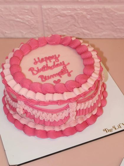 Life is always better with a touch of pink frosting. This birthday cake is a vision in pink, with layers of intricate ruffles and piping in different shades.