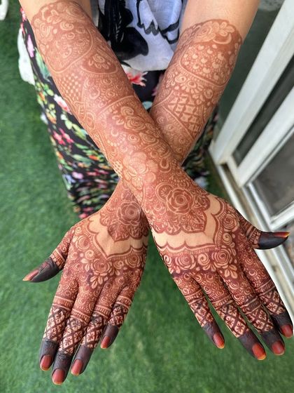 The crossed-hands pose highlights the symmetry and the beautiful, even stain of the mehendi. This is the final result of patience and good aftercare.