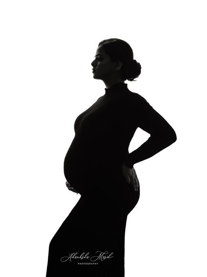 A simple, clean silhouette against a white background. This minimalist fine art style is incredibly powerful, focusing purely on the beautiful form of the mother and child.