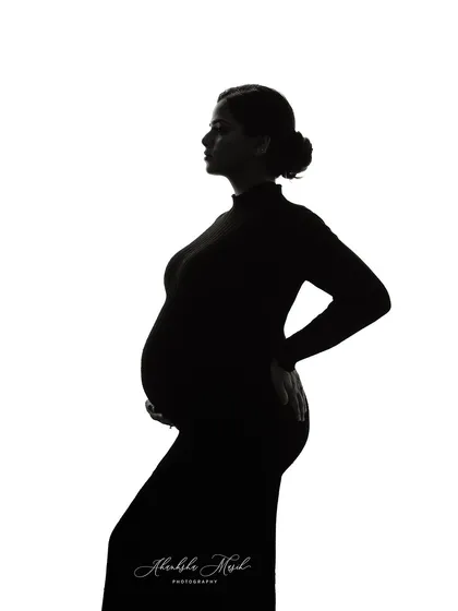 A simple, clean silhouette against a white background. This minimalist fine art style is incredibly powerful, focusing purely on the beautiful form of the mother and child.