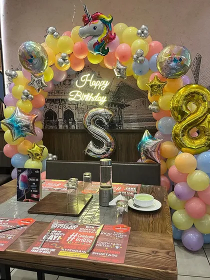 The complete table setup for an 8th birthday with a unicorn theme, ready for the cake cutting ceremony.