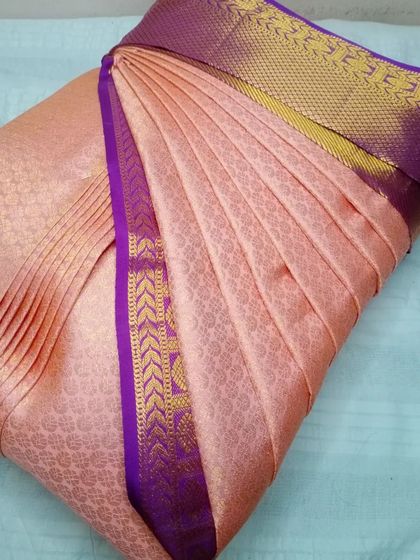 A lovely peach saree with a purple and gold border. My service is available in Jayanagar, making it convenient for you to get your sarees ready.