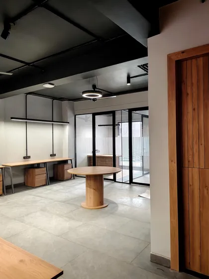 This open-plan office highlights our industrial-chic aesthetic, featuring an exposed ceiling, polished concrete floors, and sleek linear lighting. The layout is intentionally designed to foster collaboration while maintaining a clean, modern, and spacious feel.