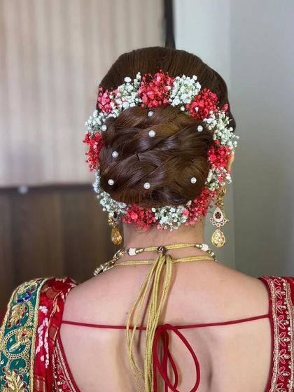 This full floral bun is a celebration of color. I used a mix of red and white flowers, dotted with pearls, to create a vibrant and joyful look for this bride's special day.