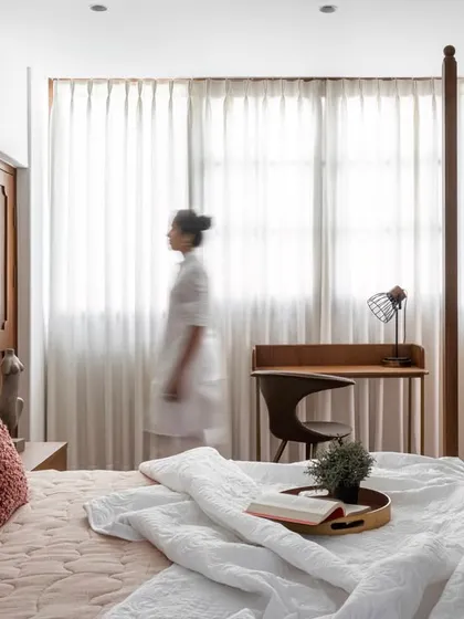 In the master bedroom, my goal is to create a visible hush. This grand four-poster bed, inspired by Kerala’s architectural roots, is balanced by soft sunlight, warm wood, and a palette of layered whites. It is a space designed not just for rest, but for stillness.