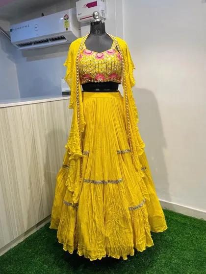 A full view of the yellow jacket lehenga, showcasing its vibrant color and modern silhouette. It's a standout piece available for rent for your Haldi function.