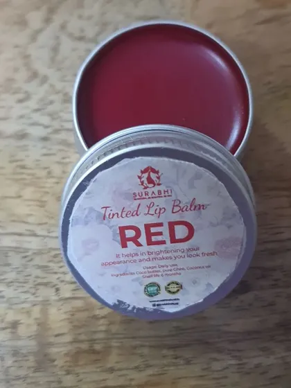 This is our Red Tinted Lip Balm, which provides a beautiful sheer color. It's made with cocoa butter and vitamin E oil to keep your lips moist and protected.