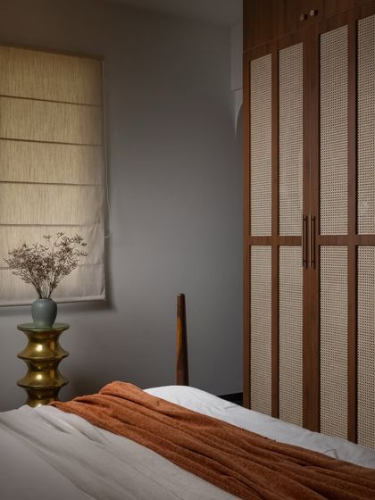 The other side of this master bedroom, showcasing a custom wardrobe with cane paneling that adds texture and warmth. The design provides plenty of storage while maintaining a calm, uncluttered feel.