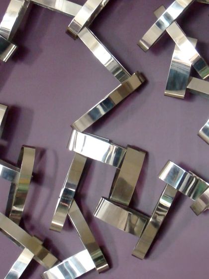 A close-up of a wall installation I created 15 years ago, playing with geometry, reflection, and rhythm using stainless steel and wood.