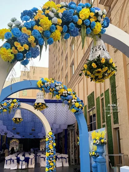 An archway decorated with blue and yellow flowers, with hanging floral bells, creating a beautiful frame for the entrance.