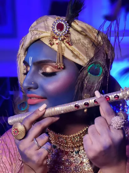 Another angle of our creative Janmashtami look, showcasing the turban, peacock feather, and golden eye makeup.