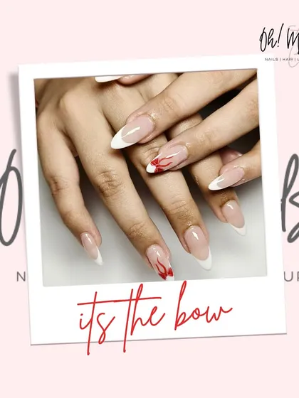 Elegance tied with a bow. This classic white French manicure is accented with a delicate, hand-painted red bow, adding a subtle pop of colour and charm.