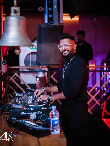 At the decks in a black turtleneck, smiling at the crowd.