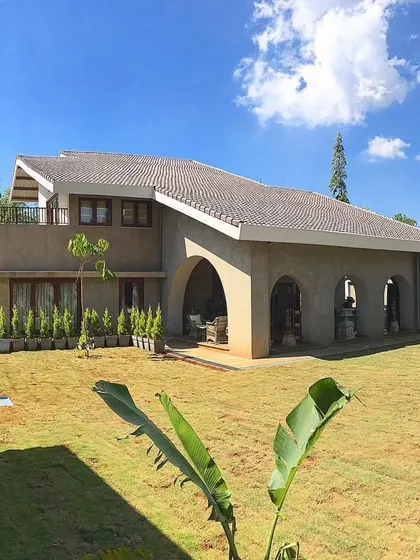 A wide shot of the Khandala villa, showing the newly laid lawn and the lines of cypress trees we planted along the entrance, which will grow to create a grand entryway.