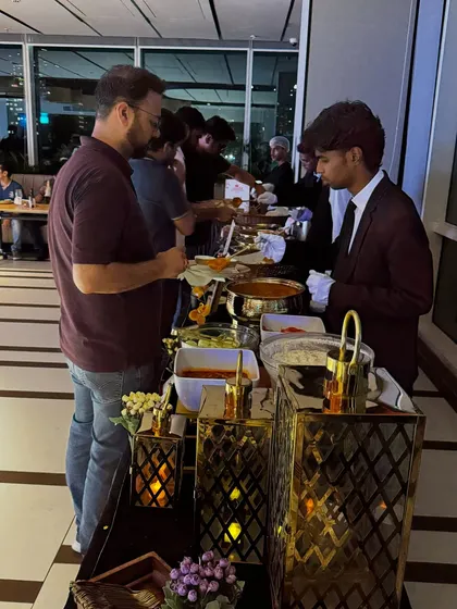 Our team is trained to provide attentive and seamless service. Here, one of our servers is assisting a guest at a corporate dinner buffet, ensuring everyone has a smooth and enjoyable dining experience.