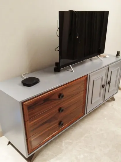 This dual-tone TV unit was delivered to a client in Greater Kailash. The combination of grey panelled doors and natural wood-grain drawers creates a sophisticated, modern-classic look.