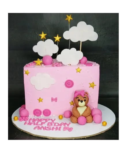 A pink teddy bear cake for a half birthday. This fresh mixed fruit cake is decorated with a cute bear, stars, and fluffy clouds for a dreamy celebration.