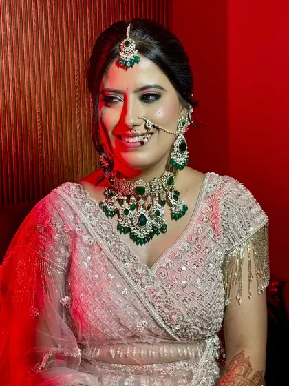 A candid, happy moment captured under dramatic lighting. Her makeup remains flawless and radiant.