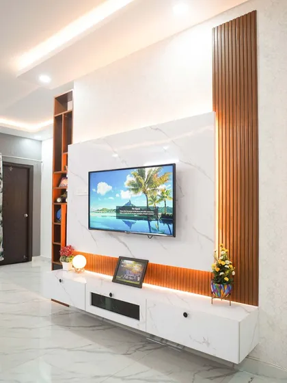 A bespoke floating entertainment unit that combines a marble-finish back panel with vertical wooden fluting for a touch of modern elegance. The design includes concealed storage and warm ambient lighting, creating a sophisticated and clutter-free focal point in the living room.