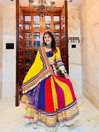 Our client strikes a pose in her vibrant Garba lehenga, a perfect blend of color, tradition, and festive energy.