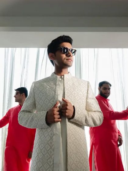 The groom and his groomsmen, ready to take on the day. Divya's confident pose, flanked by his friends in matching red kurtas, makes for a powerful and stylish group portrait.