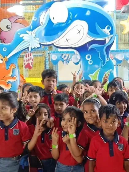 A large group of students posing for a photo during their field trip. The underwater-themed entrance arch at our Bannerghatta center makes for a great photo opportunity.